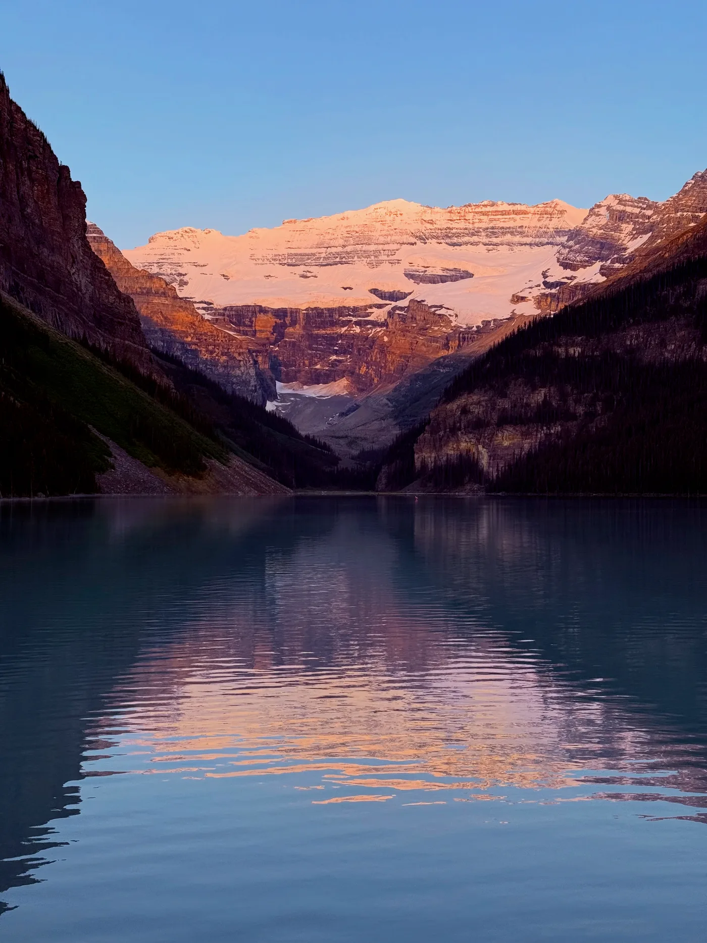 Lake Louise at sunrise with mountains reflected on the water